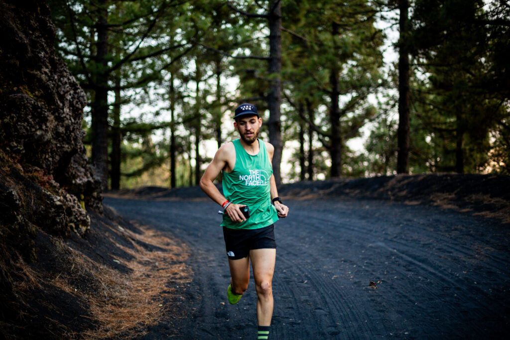 Runner on a forest trail wearing running shoes, featured in a comprehensive running shoes guide.