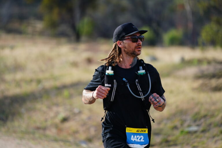 Runner competing in a trail marathon, wearing a hydration vest